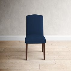 a blue chair sitting on top of a hard wood floor next to a white wall