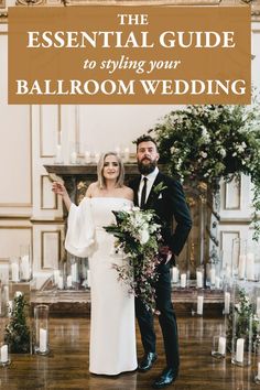 a bride and groom standing in front of an altar with candles, flowers and greenery