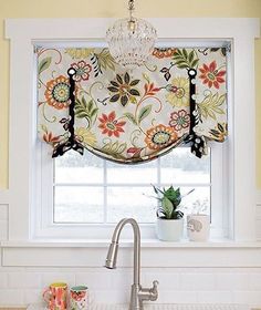 a kitchen sink under a window next to a faucet