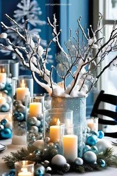 a table topped with lots of candles and christmas decorations on top of snow covered ground