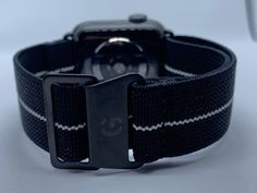 Golby Watch Straps Ltd Presents: Black with White Stripe French Marine Nationale style elasticated watch straps for Apple Watch / IWatch.  Fitting Width -  For 38mm to 40mm or 42mm to 44mm Apple IWatch Strap Colour - Black with White Stripe Strap Size - Fully adjustable to fit wrist size from 6.3 inches to 9.5 inches. The model wearing the strap has a 7.1inch wrist. Please see the sizing guide for further details. Strap - Elasticated stretch material for comfort, 22mm wide Clasp Colour - Black c Iwatch Apple, Watch Straps, Black Coat, Watch Strap, Gold Watch, Watch Bands, Apple Watch, White Stripe, Black Color