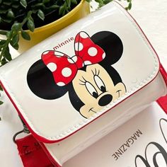 Add Some Magic To Your Style With This Charming Disney Mickey & Minnie Mouse Mini Crossbody Bag! Perfect For Disney Enthusiasts Of All Ages, This Waterproof Purse Boasts An Iconic Mickey Mouse Face On A Crisp White Backdrop, Complemented By A Vibrant Red Adjustable Strap For Comfort And Convenience. Whether You’re Running Errands Or Heading To The Parks, This Delightful Bag Is Sure To Turn Heads And Keep Your Essentials Safe In Any Weather. White Cartoon Style School Bags, Cartoon Style White School Bag, Trendy Minnie Mouse School Bag, Red Character Bag For School, Red Minnie Mouse School Bag, Disney Minnie Mouse White Bag, Cute Mickey Mouse Bags For Gifts, Disney School Bag In Red, Cute Mickey Mouse Bags As Gift