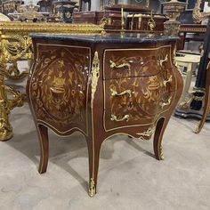 an ornately decorated chest of drawers with marble top