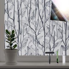 a plant is sitting in front of a window with a wallpaper pattern behind it