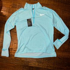 This Is A New With Tags Nike Running Long Sleeve 1/4 Zip Running Shirt. Color Is Aquamarine Or Pastel Blue. Has Never Been Worn. Smoke Free Home. No Stains. No Rips. This Top Was Originally Retailed For $89. Sale Price Was Tagged At $65. Reflective Nike Safety Swoosh On Front And “Dots” The Reflective On Back. Dri Fit Technology. Spring Sports Half-zip Top, Spring Half-zip Sports Top, Blue Stretch Half-zip Top, Nike Athleisure Half-zip Tops, Blue Half-zip Top For Spring, Blue Stretch Nike Tops, Nike Blue Tops For Spring, Light Blue Long Sleeve Sports Top, Blue Fitted Half-zip Top