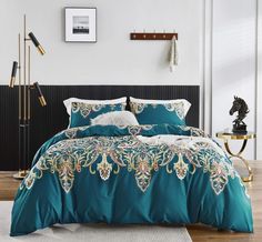 a bed with blue and white comforters in a room next to a rug on the floor