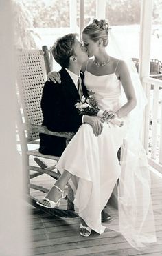 a bride and groom kissing on the porch