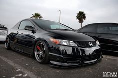 a black honda civic is parked in a parking lot