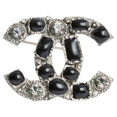 Chanel brooch from the Spring Summer 2009 collection with the CC logo motif in blackened silver metal decorated with gray rhinestones and black enameled cabochons. Width 3.7 cm x height 2.9 cm. The brooch is delivered without original packaging or invoice, it is in excellent condition, perfect for every day... This item is perfect worn with a beautiful Hermès Kelly, Birkin or Constance bag, a nice Dior necklace, a pair of Gucci glasses, and a Saint Laurent or Céline cape... Broche Chanel, Dior Necklace, Chanel Brooch, Gucci Glasses, Chanel Jewelry, Jewelry Lookbook, Cc Logo, Luxury Brands, Angelina Jolie