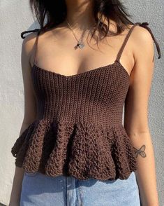 a close up of a person wearing a tank top with crochet on it