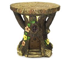 a tree stump table with a birdhouse on it's side and flowers painted all over the top