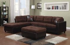 a living room with a brown sectional couch and ottoman