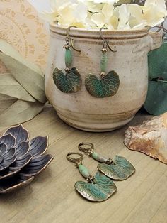 Wear a piece of botanical beauty with these amazing earrings! Antiqued brass ginkgo leaves with a touch of green verdigris will make a statement and delight your friends. Magnesite beads and brass accents will take them over the top and make them the star of any outfit. Antiqued brass verdigris leaf charms Magnesite elongated beads Brass accents Lever back ear closures Drop Length 2" Created in studio - Wilmington, NC