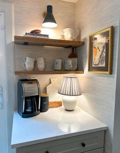 a kitchen counter with a lamp on top of it and coffee cups in the corner