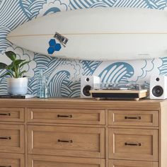 a white surfboard sitting on top of a wooden dresser