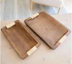 two wooden trays sitting on top of a table