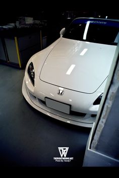 a white sports car parked in a garage