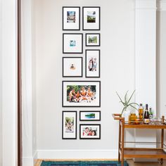 a wall with many pictures on it and a blue rug in front of the floor