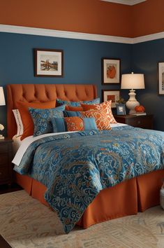 a bedroom with blue and orange bedding in the corner, two lamps on either side of the bed