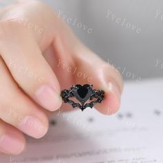 a woman's hand holding an engagement ring with black diamonds on it and the words i love you