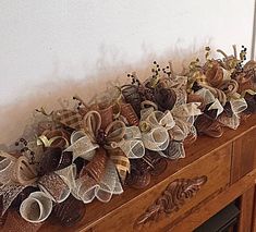 a wooden table topped with lots of fake flowers and ribbons on it's sides