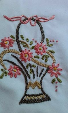 a white shirt with pink flowers on the front and back, embroidered in gold thread