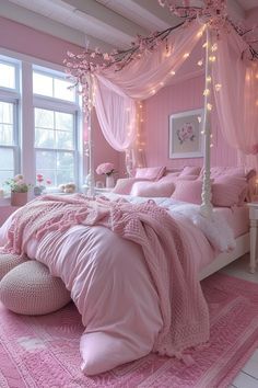 a bed with pink sheets and pillows on top of it in a room filled with windows