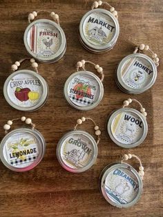 six tin can ornaments are hanging on a wooden table with beaded string around them