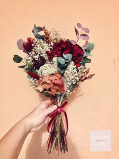 a person holding a bunch of flowers in their hand