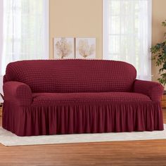 a living room with a couch covered in a red cover