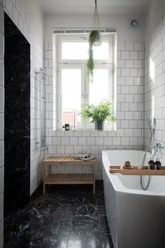 A bathroom with black marble floors and white subway tiles on the walls Marble Bathroom Ideas, Modern Marble Bathroom, Grey Marble Bathroom, Black Marble Floor, Grey Stone Wall, Marble Bathroom Floor, White Marble Bathrooms