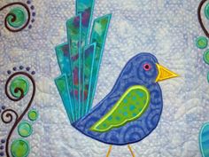 a blue bird sitting on top of a quilt