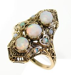 BEAUTIFUL 9CT/9K SOLID GOLD & OBLONG NATURAL OPAL VINTAGE RINGThis STUNNING Vintage Inspired ring has been majestically crafted from 9ct Solid Yellow Gold. Three claw set Round Cut NATURAL Opals brings this ring to life along with six accentuating NATURAL Opals claw set on each side of the ring. The entire face has a detailed filigree pattern including flowers engraved on the shoulders adding additional appeal to this exquisitely feminine ring. Surrounding the face of this GORGEOUS ring are Gold Opal Ring In 14k, Unique Gold Opal Ring In 14k, Yellow Gold Multi-stone Art Deco Jewelry, Antique Three Stone Gold Jewelry, Antique Gold Three-stone Jewelry, Collectible Opal Ring In 14k Gold, Antique Three Stone 14k Gold Jewelry, Unique Multi-stone Opal Ring In Gold, Art Deco Multi-stone Yellow Gold Jewelry