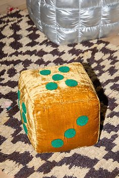 a yellow and green dice sitting on top of a rug