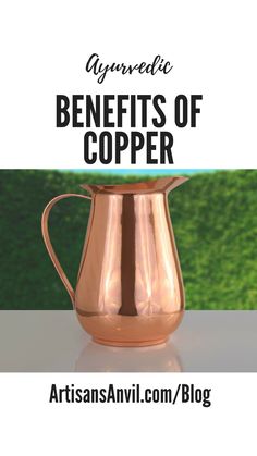 a copper pitcher sitting on top of a table