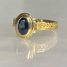 A modern and timeless vintage 14k yellow gold ring featuring an oval shaped sapphire weighing 0.95 carats securely set in a tiered bezel which elevates the stone above the finger with hand crafted detailing along the band. *Ring size: US 6 1/2 * Ring weight: 4.03 grams Gold Oval Cabochon Sapphire Ring For Formal Occasions, Gold Sapphire Ring With Oval Cabochon For Formal Events, Formal Gold Oval Cabochon Sapphire Ring, Formal Gold Sapphire Ring With Oval Cabochon, Classic Oval Sapphire Ring With Polished Finish, Classic 14k Gold Sapphire Oval Cabochon Ring, Classic Yellow Gold Sapphire Ring Oval Cabochon, Classic Oval Sapphire Ring, Elegant Sapphire Signet Ring