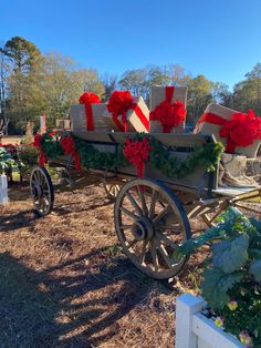 a horse drawn carriage with presents on it's back and red bows tied to the sides