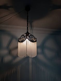 a chandelier hanging from the ceiling in a room with shadows on the wall