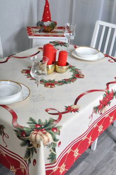 the table is set for christmas dinner with red candles