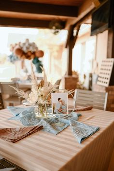 the table is set with flowers and pictures