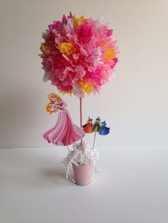 a flower pot with some paper flowers in it and a princess figure next to it