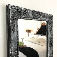 a mirror reflecting a bed in a bedroom