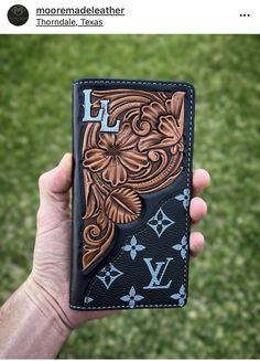 a hand holding up a wallet with an intricate design on the front and back side