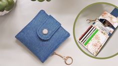 a blue wallet sitting on top of a table next to a flower pot and keychain