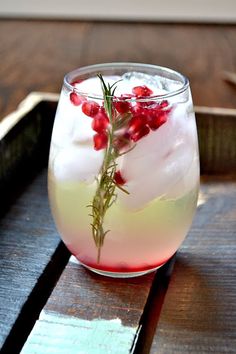 a glass filled with liquid and garnish on top of a wooden table