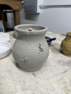 a white vase sitting on top of a table