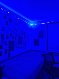 a bed in a room with blue lights on the walls and pictures on the wall