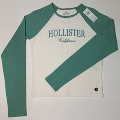 New Hollister Long-Sleeve Logo Graphic Flocking Baby Tee Size M Fall Letter Print Raglan Sleeve Top, Green Long Sleeve Top With Letter Print, Spring Stretch Tops With Logo Print, White Casual Long Sleeve Top With Graphic Print, White Fitted Cotton Long Sleeve Top, Fitted White Cotton Long Sleeve Top, White Raglan Sleeve Top For Fall, Winter Raglan Sleeve Top With Letter Print, Winter Tops With Letter Print And Raglan Sleeve