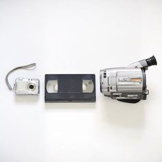 an old video camera sitting on top of a white table next to a flash drive