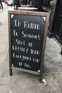 a sign on the sidewalk that says i'd rather be someones shot of whiskey than everyone cup of tea